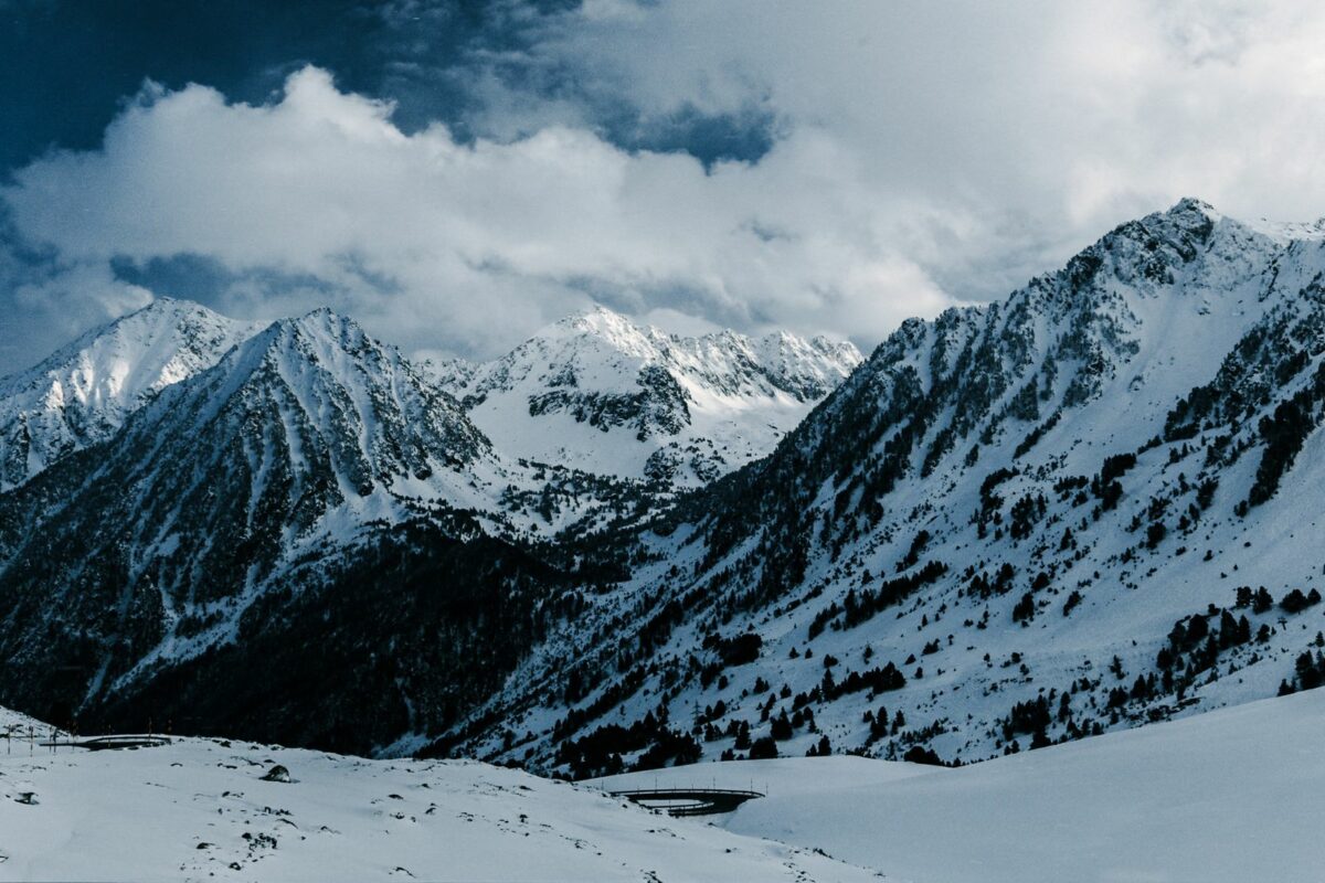 Sommets enneigés des Pyrénées en hiver sous un ciel nuageux
